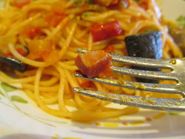 サイゼリヤ彩り野菜のトマトソーススパゲッティのベーコンを持ち上げ